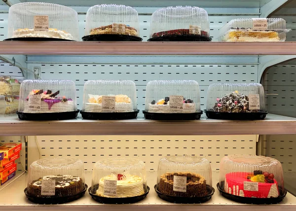 View of the cake shelves in the store, a lot of cakes in the store, the product line with cakes, product shelves in the market