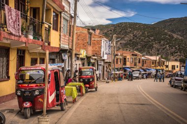 Bolivya 'nın Cotagaita kenti, caddelerde taksi-motosikletleri, yol üzerinde inşaatlar ve arka planda dağlarla. Güney Bolivya.