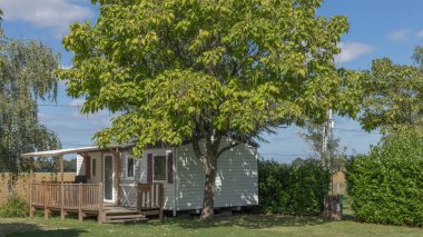 Bina beyaza boyanmış ve yan tarafında üzüm bağı var.