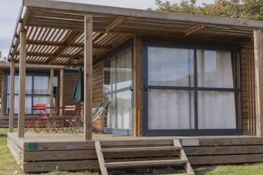 Üzerinde paslanmaz çelik lavabo olan küçük beyaz bir kulübe.