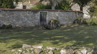 Küçük bir köprüsü ve kapalı bir kapısı olan bir duvarda geçit.