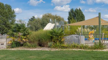 Açık yüzme havuzu, su kaydırağı ve mavi gökyüzü. Gölgeye yelken aç.