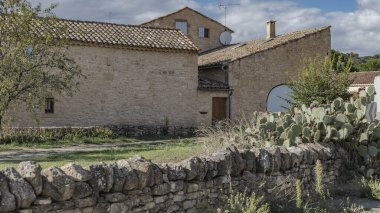 Bal renkli taştan yapılmış büyük kemerli mavi kapılı şaraphane binası.