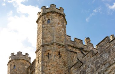 Bal rengi bir şato kulesinin tepesine, haçtaki ok deliklerine bakan güzel mavi gökyüzüne bakıyorum.