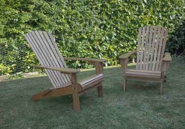 Eski moda ahşap şezlonglar bir çitin üzerinde oturuyordu.