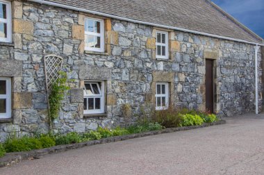 Kapısı ve çardağı olan bir taş binaya bakan uzun bir patika.