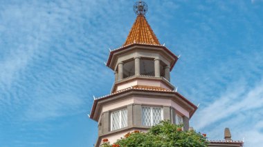 Üzerinde eşsiz yuvarlak metal bir top olan mavi gökyüzüne karşı Octaganol kulesi.