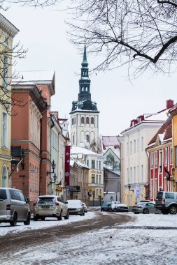 Tallinn, Estonya - 25 Aralık 2018: Lai Caddesi 'ndeki binaların ve arabaların manzarası ve Tallinn Eski Kasabası' ndaki Aziz Nicholas Kilisesi 'nin kulesi