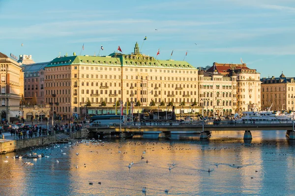 Stockholm, İsveç - 26 Aralık 2018 Strombron Köprüsü 'nün panoramik manzarası ve güneşli kış gününde Norrstrom Nehri' nin setindeki tarihi binalar