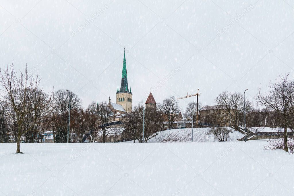 Panoramic view of the park on the background of walls and towers of Tallinn Old Town in snowy winter day, Estonia