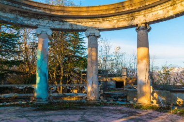 Colonnade of the abandoned building of the former restaurant on the top of Mount Akhun in sunny autumn day, Sochi, Russia