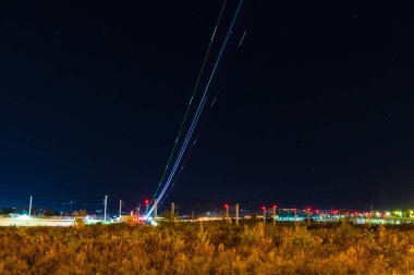 Light trails of plane taking off on the background of night sky with stars, Adler, Sochi, Russia