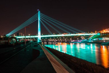 Alacakaranlıkta Tura Nehri üzerindeki aydınlık Aşıklar Köprüsü 'nün güzel manzarası, Tyumen, Rusya