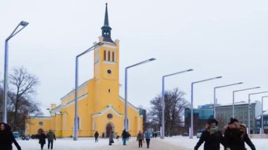 Tallinn, Estonya - 25 Aralık 2018: Yakınlaştırmalı hızlandırılmış video. Azize John Kilisesi 'nin Özgürlük Meydanı' ndaki görüntüsü. Bir kış günü yürüyen bir kalabalıkla birlikte.