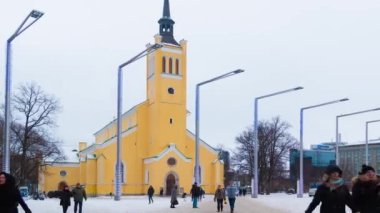 Tallinn, Estonya - 25 Aralık 2018: Uzaklaştırılmış video. Azize John Kilisesi 'nin Özgürlük Meydanı' ndaki görüntüsü. Bir kış günü yürüyen bir kalabalıkla birlikte.