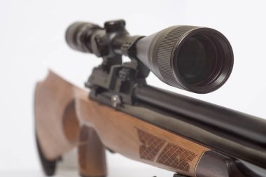 Çift ayaklı uzun menzilli bir havalı tüfek ve beyaz arka planda optik görüş ve bipodlar ve beyaz üzerinde optik görüş. 