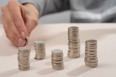 a hand putting ukrainian coins on the table