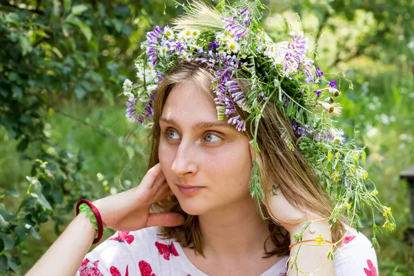 Kır çiçeklerinin içinde genç tatlı bir kız - portre