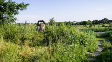 Nehrin kıyısındaki bir tarlada kovası olan eski, ilkel bir kuyu.
