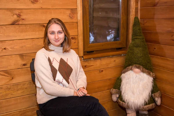 Ein Mädchen Einer Winterblockhütte Sitzt Zusammen Mit Einem Dekorativen Waldzwerg — Stockfoto