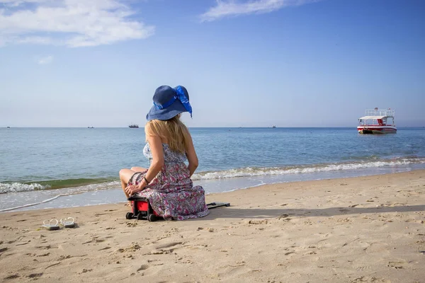 Mladá Dívka Sedí Kufru Písečném Pobřeží Slunečních Šatech Kloboukem Ráno — Stock fotografie