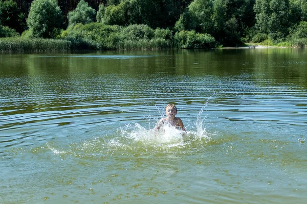 一个男孩在森林湖中洗澡 跳入水中 — 图库照片