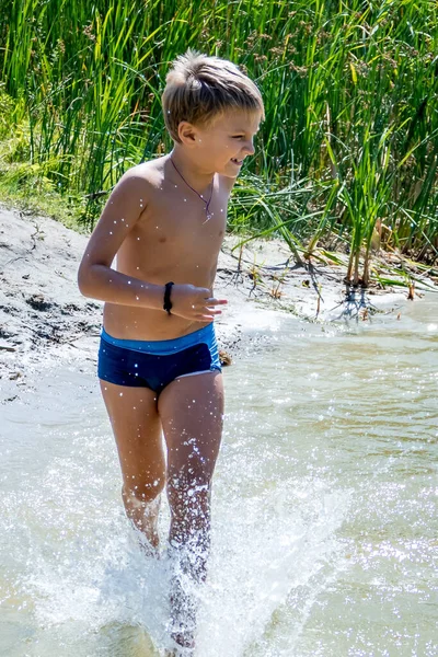 Ein Junge Badet Einem Waldsee Springt Ins Wasser lizenzfreie Stockfotos