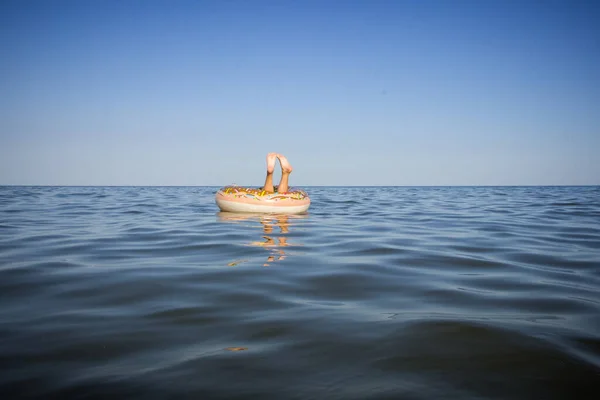 Dívčiny Nohy Vyčnívají Nafukovacího Kruhu Vznášejícího Moři — Stock fotografie