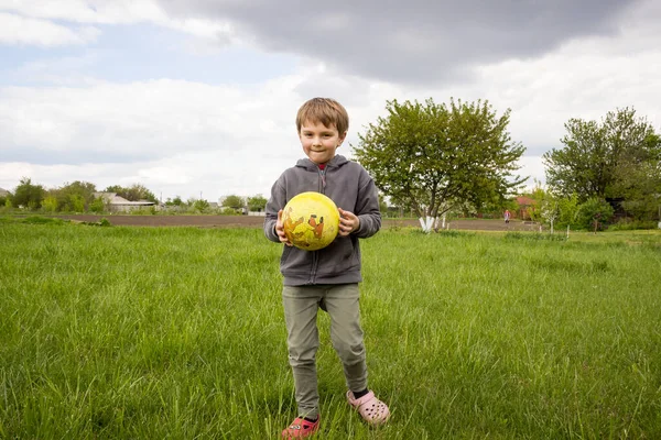 Niño Pequeño Con Una Pelota Camina Primavera Césped Verde —  Fotos de Stock