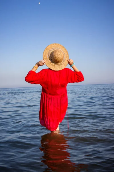 Young Girl Straw Hat Red Dress Sea Stands Her Back — Stock Photo, Image