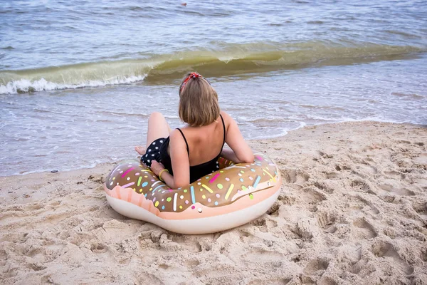 Uma Menina Senta Com Costas Anel Inflável Olha Para Mar — Fotografia de Stock