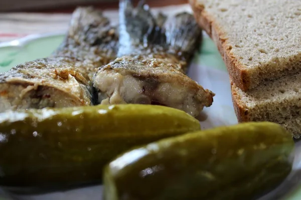 Kızarmış balık, turşu ve bir tabak ekmek.