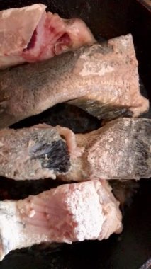 Nehir balığı parçaları eski bir tavada pişirilir.