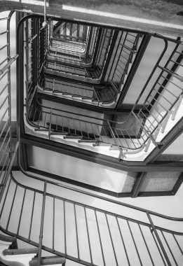 Aşağıdan yukarıya manzaralı spiral dikdörtgen merdiven. Siyah beyaz fotoğraf