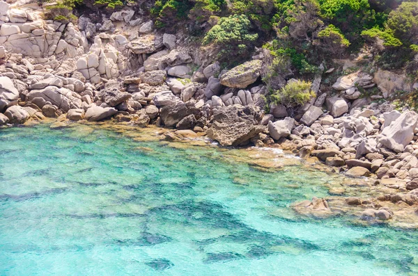 Kocaman taşları ve masmavi deniz suyuyla ıssız bir körfez.