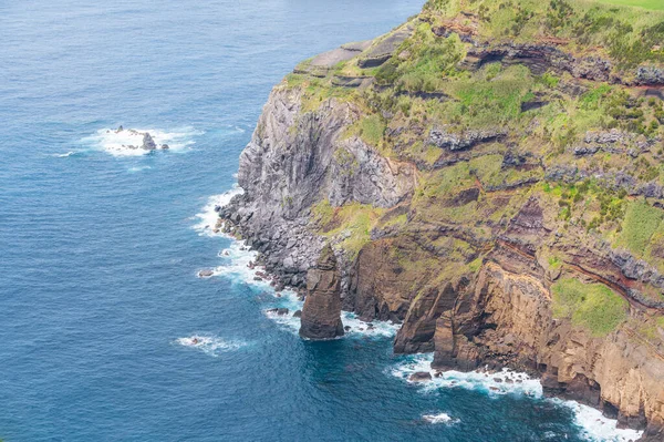 Egy Függőleges Kőoszlop Áll Óceán Partján Egy Magas Zöld Szikla — Stock Fotó