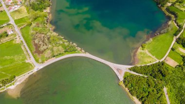 Azorelar 'dan birinin üzerindeki iki farklı renk gölünün arasındaki baraj boyunca bir yol. Yukarıdan görüntüle