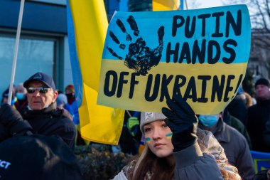 Toronto, ON, Kanada 25 Şubat 2022: Ukrayna yakınlarındaki Rus saldırganların Ukrayna 'daki savaşına karşı düzenlenen gösteri sırasında Ukrayna konsolosluğu yakınlarında bayraklı protestocular.