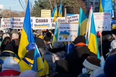 Toronto, ON, Kanada 25 Şubat 2022: Ukrayna yakınlarındaki Rus saldırganların Ukrayna 'daki savaşına karşı düzenlenen gösteri sırasında Ukrayna konsolosluğu yakınlarında bayraklı protestocular.