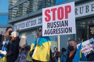 Toronto, ON, Kanada 25 Şubat 2022: Ukrayna yakınlarındaki Rus saldırganların Ukrayna 'daki savaşına karşı düzenlenen gösteri sırasında Ukrayna konsolosluğu yakınlarında bayraklı protestocular.