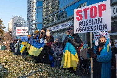 Toronto, ON, Kanada 25 Şubat 2022: Ukrayna yakınlarındaki Rus saldırganların Ukrayna 'daki savaşına karşı düzenlenen gösteri sırasında Ukrayna konsolosluğu yakınlarında bayraklı protestocular.