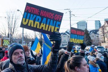 Toronto, ON, Kanada 25 Şubat 2022: Ukrayna yakınlarındaki Rus saldırganların Ukrayna 'daki savaşına karşı düzenlenen gösteri sırasında Ukrayna konsolosluğu yakınlarında bayraklı protestocular.