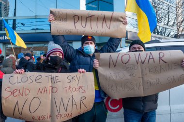Toronto, ON, Kanada 25 Şubat 2022: Ukrayna yakınlarındaki Rus saldırganların Ukrayna 'daki savaşına karşı düzenlenen gösteri sırasında Ukrayna konsolosluğu yakınlarında bayraklı protestocular.