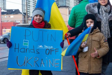 Toronto, ON, Kanada 25 Şubat 2022: Ukrayna yakınlarındaki Rus saldırganların Ukrayna 'daki savaşına karşı düzenlenen gösteri sırasında Ukrayna konsolosluğu yakınlarında bayraklı protestocular.