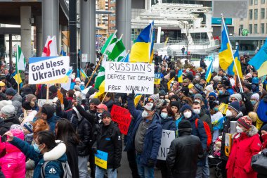 Toronto, Ontario, Kanada 27 Şubat 2022: Ukrayna 'daki Rus işgaline karşı düzenlenen bir gösteri sırasında Nathan Phillips Meydanı' nda pankartlı ve Ukrayna bayraklı protestocular