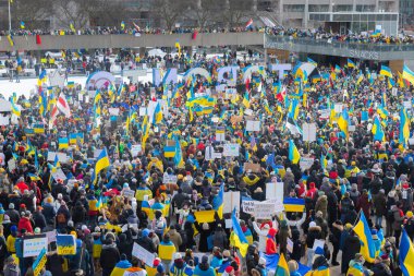 Toronto, Ontario, Kanada 27 Şubat 2022: Ukrayna 'daki Rus işgaline karşı düzenlenen bir gösteri sırasında Nathan Phillips Meydanı' nda pankartlı ve Ukrayna bayraklı protestocular