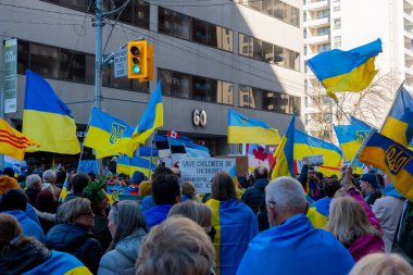 Toronto, Ontario Canada 6 Mart 2022: Toronto 'daki Rus konsolosluğu yakınlarında sarı ve mavi Ukrayna bayraklı göstericiler Ukrayna' daki savaş sırasında Ukrayna üzerindeki hava sahasını kapatma talebinde bulundu