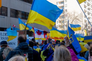 Toronto, Ontario Canada 6 Mart 2022: Toronto 'daki Rus konsolosluğu yakınlarında sarı ve mavi Ukrayna bayraklı göstericiler Ukrayna' daki savaş sırasında Ukrayna üzerindeki hava sahasını kapatma talebinde bulundu