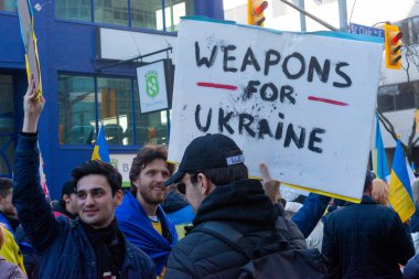 Toronto, Ontario Canada 6 Mart 2022: Toronto 'daki Rus konsolosluğu yakınlarında sarı ve mavi Ukrayna bayraklı göstericiler Ukrayna' daki savaş sırasında Ukrayna üzerindeki hava sahasını kapatma talebinde bulundu