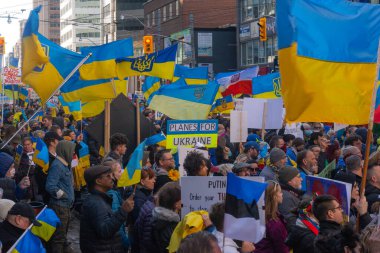 Toronto, Ontario Canada 6 Mart 2022: Toronto 'daki Rus konsolosluğu yakınlarında sarı ve mavi Ukrayna bayraklı göstericiler Ukrayna' daki savaş sırasında Ukrayna üzerindeki hava sahasını kapatma talebinde bulundu